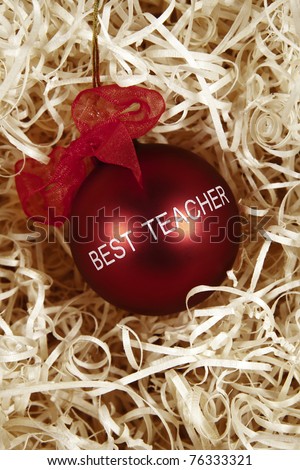 close up detail image of glass bauble with the words best teacher printed on it