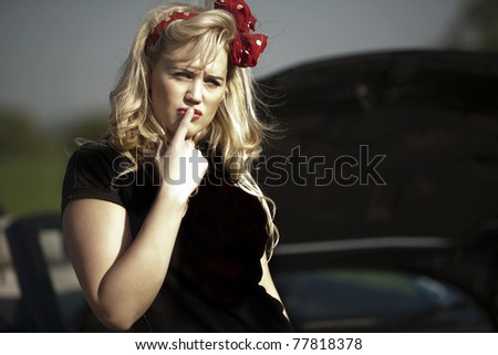 young sexy woman broken down in her open top sports car hoping to get help