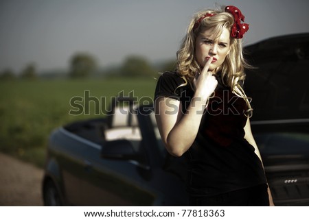 young sexy woman broken down in her open top sports car hoping to get help