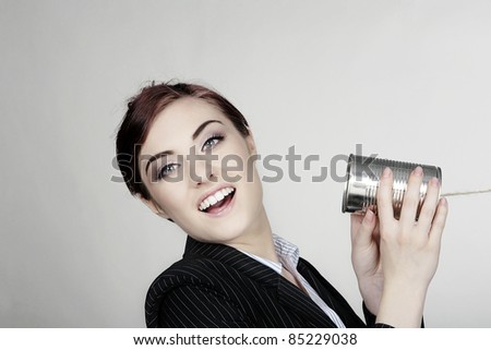 woman in a smart business suit in communication using a tin can and string