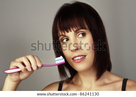 woman in black underwear brushing her teeth