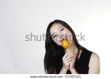 woman looking happy holding a toffee apple she about to eat