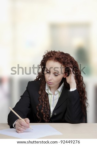 woman at her desk writing on paper