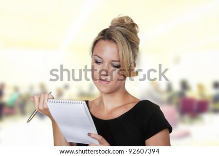 woman shot in the studio on white background holding a pen and note book talking notes