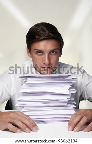 business man at his desk at work with lots of paper work to do