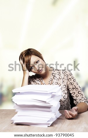 woman at her desk with lots of paper work to do