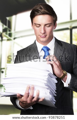business man holding in his arms a lager pile of paper work
