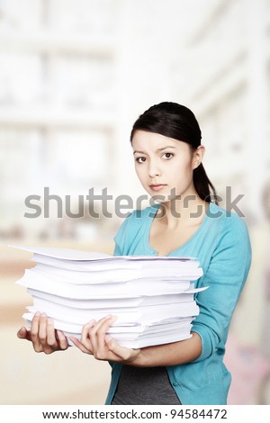 woman hold a lot of paper almost to much to carry
