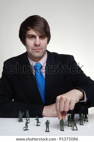 business man playing with toy soldiers