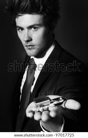 low key portrait image of businessman holding up a pad lock