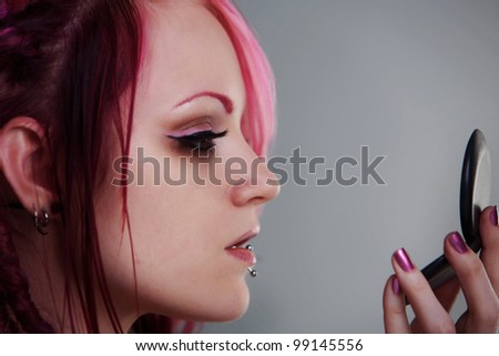 woman with dread lock hair doing her make up