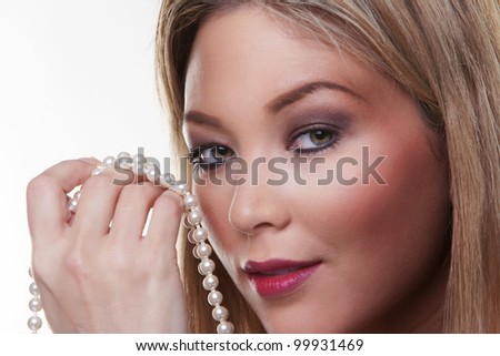 heand of beautiful female model holding a pearl necklace