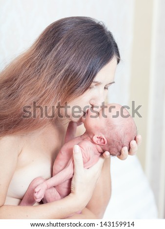 Mother holding a newborn baby skin-to-skin contact