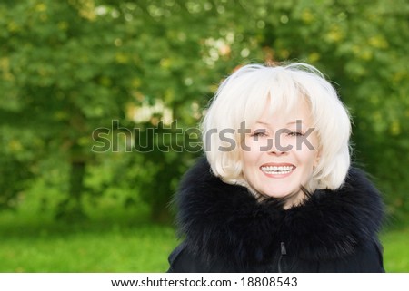 Portrait of young smiling woman on natural green background