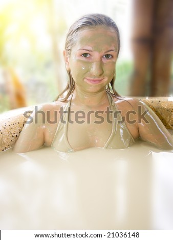 Young woman in mud bath outdeer.