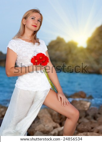 Young fashion woman with flowers near the ocean