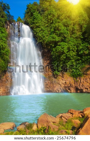 Waterfall with rainbow in rain forest