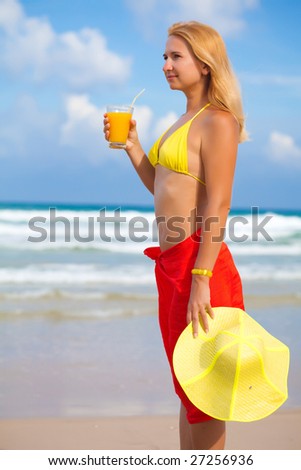 Woman with juice on the tropical beach