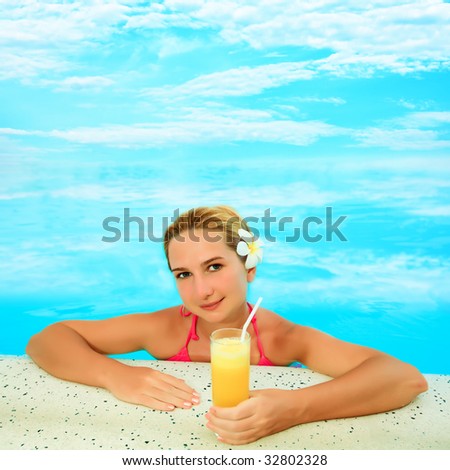 Young woman with juice in infinity pool