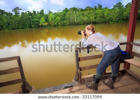 Young woman with camera. Expedition to lake.