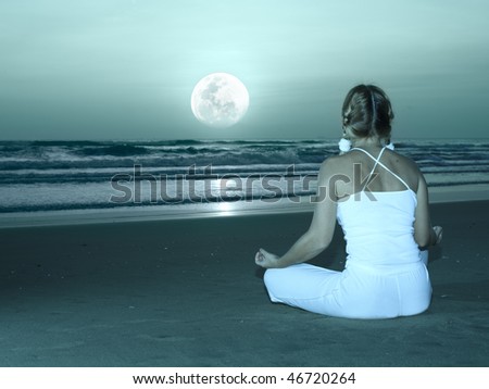 Woman is meditating at twilight time under moon