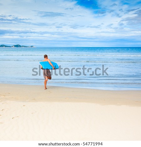 Man with body board on the tropical beach