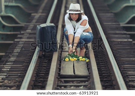Young woman on train track holding flowers