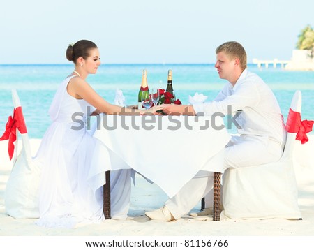 stock photo Bride and groom at wedding table on the beach