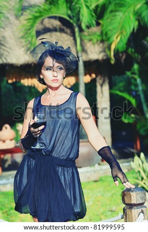 Fashion woman portrait with glass of wine outdoor
