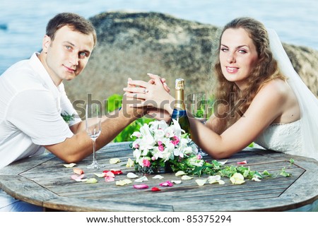 stock photo Bride and groom at wedding table near the sea