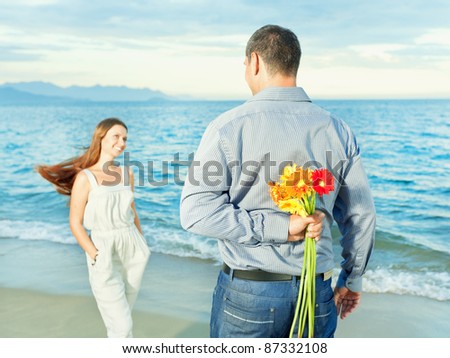Man with flowers for his woman. Focus on a flowers
