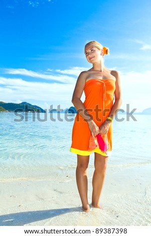 Woman in orange dress on the tropical beach