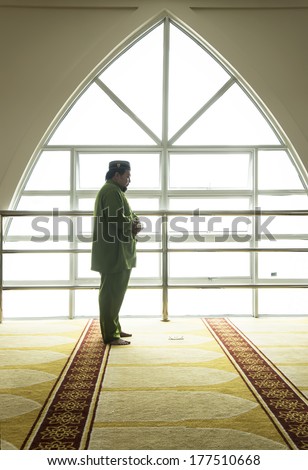 A highkey image of a Muslim prays