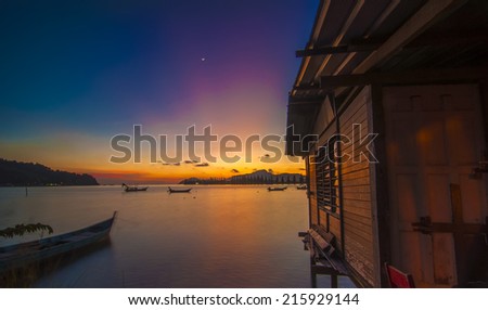 Magical rays of light during sunrise at tropical beach.  Fisherman House on the sea