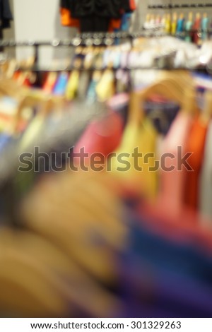 clothes on a rack on a flea market in bokeh. Defocus background