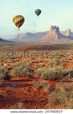 Hot air balloons floating over the southeastern desert of Utah in Valley of the Gods near the city of Bluff at sunrise.