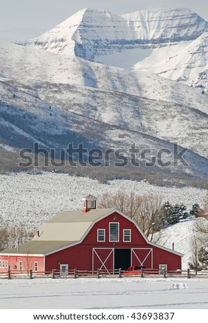 Large red barn in the mountain snow.