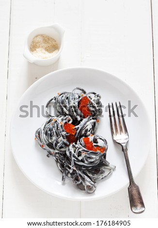 Black pasta with cream sauce and red caviar
