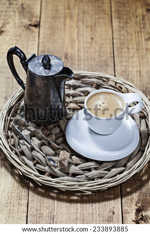 Cup of coffee and creamer on a straw tray