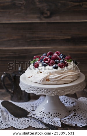 Pavlova cake with fresh berries on a cake stand