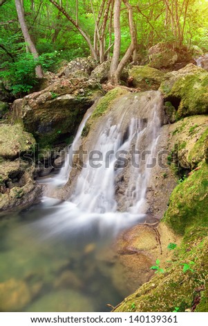 Waterfall. Mountain river. A stream of water in forest and mountain terrain.