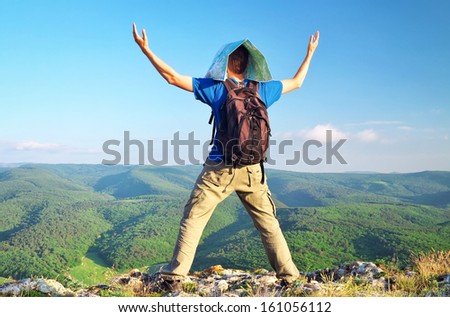 Man with a map watching the layers of endless hills from the top of mountain. Man on top of mountain