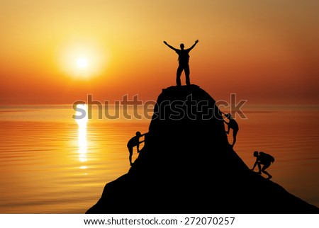 Silhouette of a mans on a mountain top on sunset background. Sport and active life concept