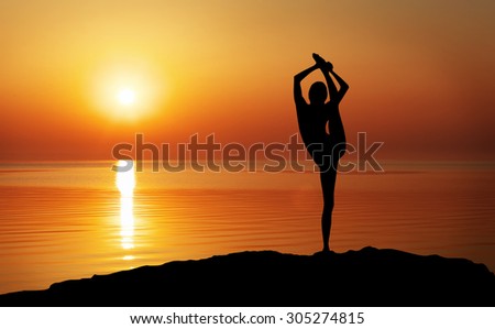 Silhouette of a woman Yoga in the evening. Woman doing Yoga at sunset