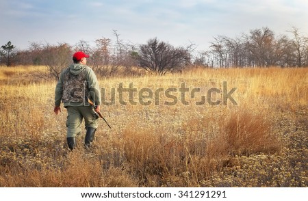 Hunter moving with shotgun looking for prey. Hunter with a gun. Hunting for hare