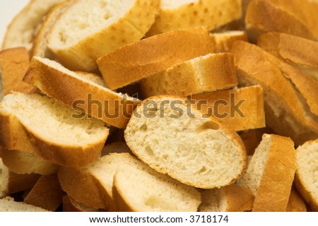 Full frame image of slices of white french loaf. The slices are thrown together in a basket