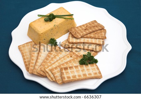 Pike terrine and melba toast, with parsley and chives as garnishing on a white platter. The image is shot from above