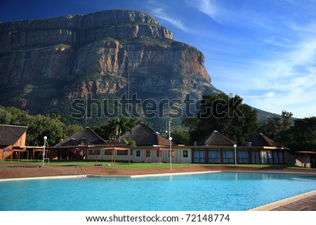 A clear, bright swimming pool against a mountain backdrop at a holiday destination in South Africa