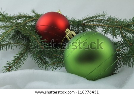 Red and green Christmas bulbs, with needles on white background