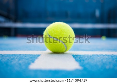 Yellow tennis balls in court on blue turf